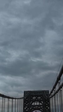 point of view of car driving over george washington bridge between fort lee new jersey and manhattan york heights (sunset night time cloudy suspension bridge)