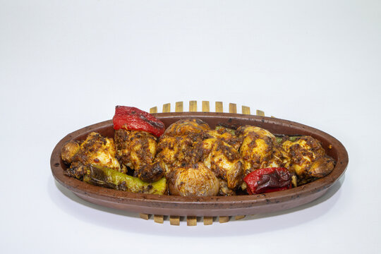 Chicken kebab in an earthenware pot, baked in the oven, photograph on a white background