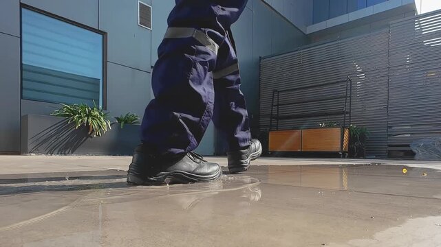 Industrial Worker Walking Across Wet Surface in Dramatic Low Angle Shot