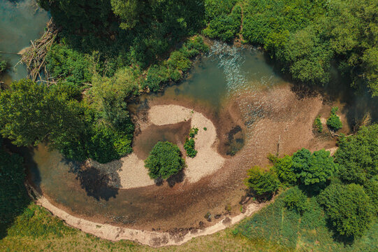 Aerial view of the Wasserwiesen river bend featuring gravel banks and lush green trees in Biberach an der Riss, Baden-Wurttemberg, Germany.