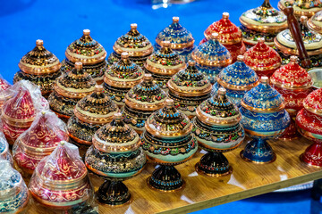 Fototapeta premium Metal coffee cezve with decorative oriental pattern on the shop window. Household items copper items for sale. Cupric coffe epots at the bazaar in Antalya Turkey. Turkish coffee pots. Metal coffee cez