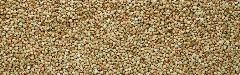 Naklejka premium Detailed view on buckwheat grains in big pile on table close up
