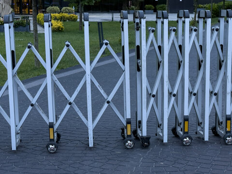 Retractable metal barrier with wheels, suitable for crowd control, event management, or temporary security.