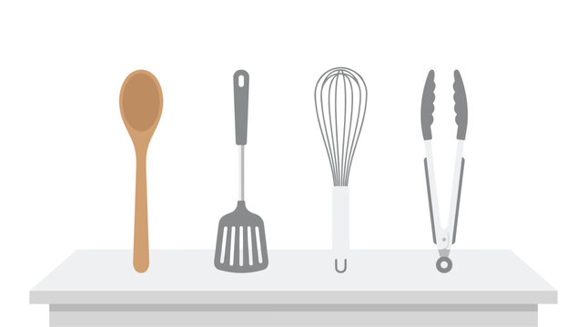 Various essential kitchen utensils including a spoon, spatula, whisk, and tongs are neatly arranged on a flat surface against a plain white background.