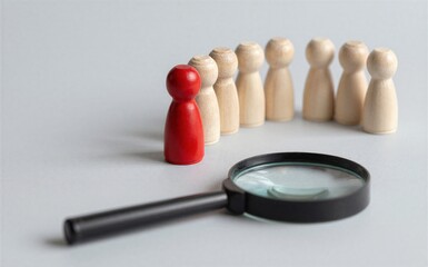 Fototapeta premium Red figure stands out among wooden peers magnifying glass nearby