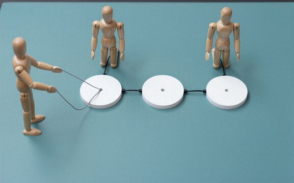 Wooden figures connect with wires to white circular plates on a teal