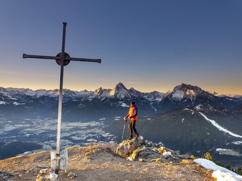 Mountaineers at the summit cross Rauher Kopf at sunrise, in the background the Berchtesgaden Alps, Steinernes Meer, Sch&ouml;nfeldspitze, Watzmann and Hochkalter, Berchtesgaden National Park, Bischofswiesen, Berchtesgadener Land, Upper Bavaria, Bavaria, Germany