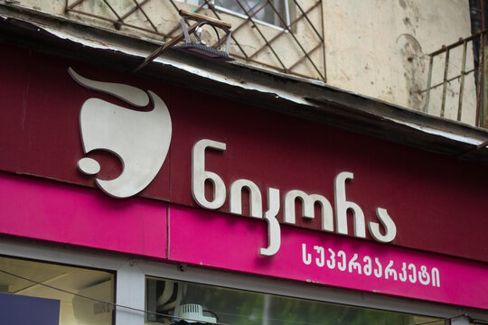 Tbilisi, Georgia - May 23, 2026: Street city photo close up. Georgian shop logo of Nikora market with head of cow, bison, bull on wall of mass market food grocery store. Black friday sale, 11 november