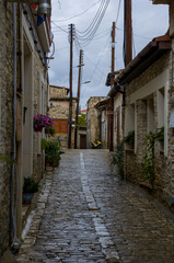 Fototapeta premium Narrow cobblestone alley with rustic stone walls and wooden doors