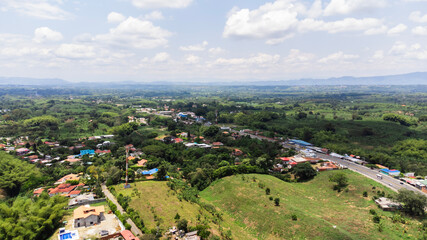 Obraz premium Aerial view Green area near Armenia, quindio Colombia, Sunny day forest area, nature tree zone, fliying over road, building background 4k