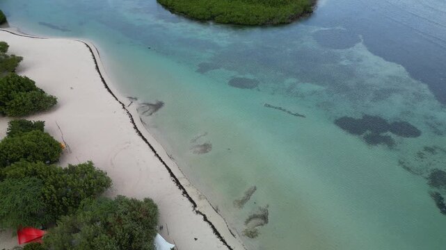 Drone view over shallow tropical waters and mangrove islands at La Cobita Beach in Azua with peaceful ocean atmosphere and untouched coastline.