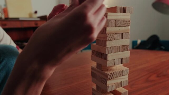 Focused Hands Playing Stacking Blocks Jenga Game