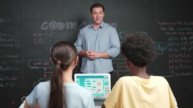 Handsome teacher clapping hands to celebrate successful project while diverse student raised arms with happiness. Instructor applause high school children to inspire to coding program Edification