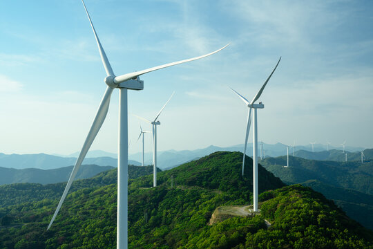 Wind Turbine Farm on a Forested Mountain Ridge at Golden Hour. Wind turbines generate clean renewable energy.