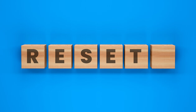 Reset Button on Blue Background: Wooden blocks with the word RESET are neatly arranged against a vibrant blue background, symbolizing a fresh start or a new beginning.