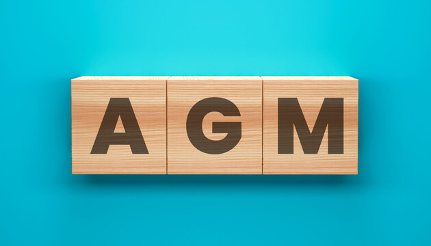 AGM Blocks: Three wooden blocks spelling out AGM rest on a vibrant blue background, symbolizing corporate meetings and decision-making.