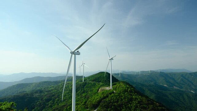 Timelapse of a Wind Turbine Farm on a Forested Mountain Ridge at Golden Hour. Wind turbines generate clean renewable energy.