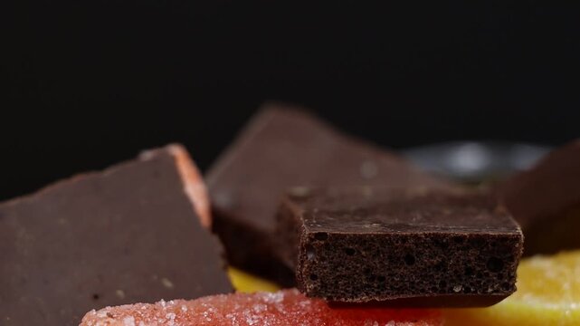 Close-up rotating shot of porous chocolate with colorful marmalade.