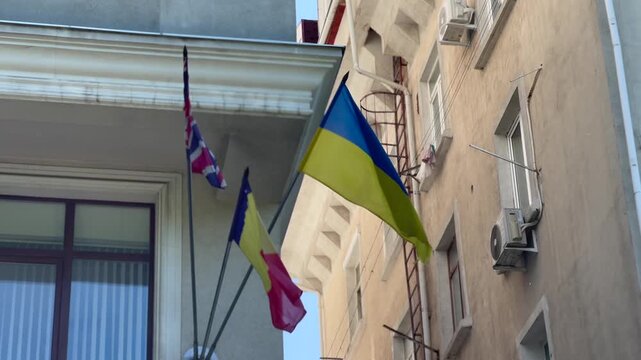 Ukrainian, Romanian and British Flags Flying on Building Facade in Chisinau Moldova
