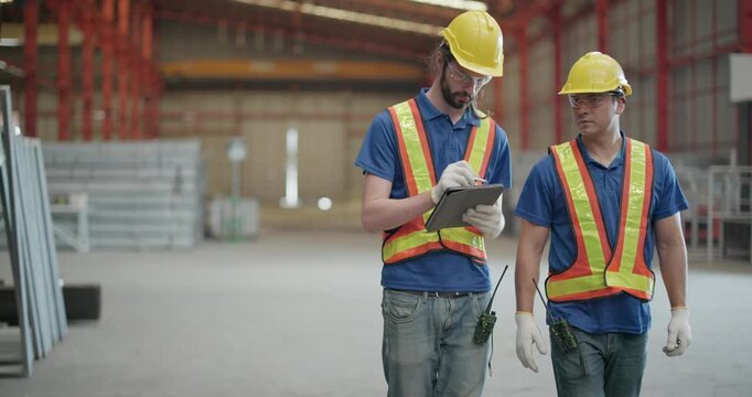 Metal Fabrication Workers Inspecting Quality and Reviewing Work Orders in Industrial Warehouse