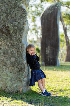 laughing child leaning on Iconic Australian standing stones enjoying the Glen Innes Highlands
