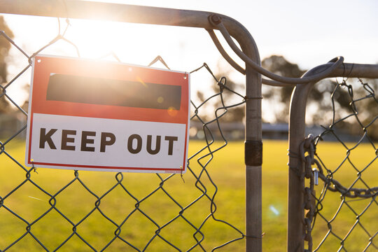 keep out sign on the latched gate at a sports club