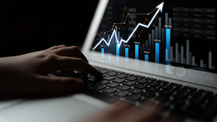 Close-up of a laptop displaying financial graphs with upward trends. Ideal for business, finance,...
