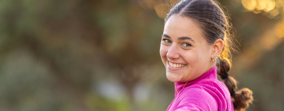 head and shoulders of teen girl looking back at camera and smiling