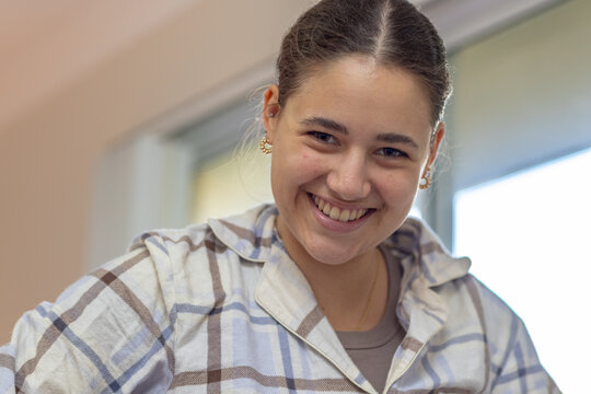 head and shoulders of teenager in pyjamas with a window behind