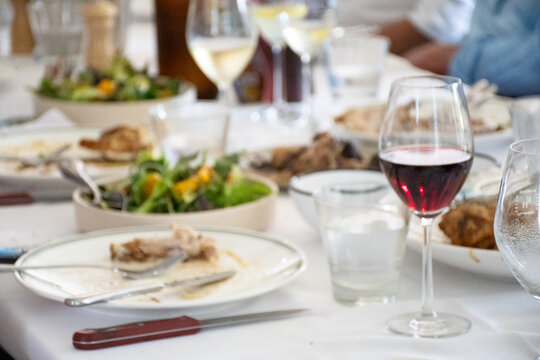 Close up of dining table with glass of red wine in focus