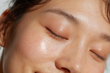Fototapeta premium Dewy Korean skin close up with smooth reflective texture, healthy glow, natural complexion and visible pore detail conveying freshness and calm