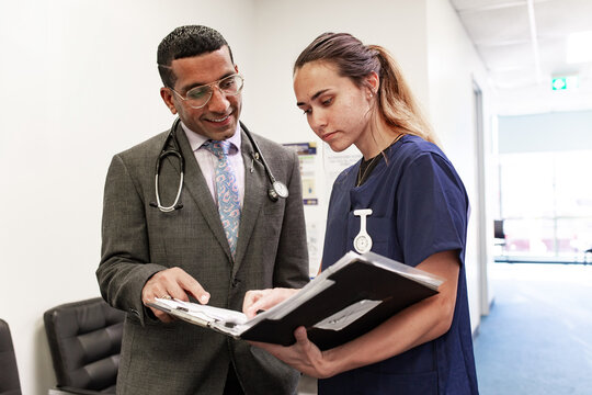 Clinicians discussing case files in medical facility