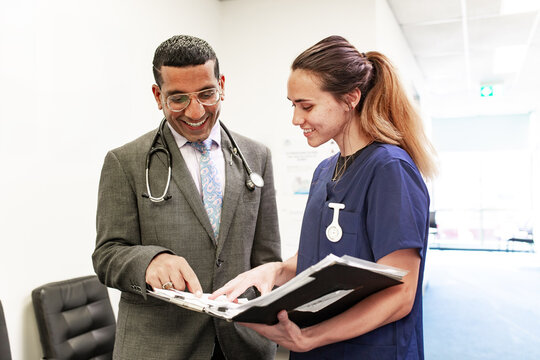 Clinicians discussing patient records in hospital setting