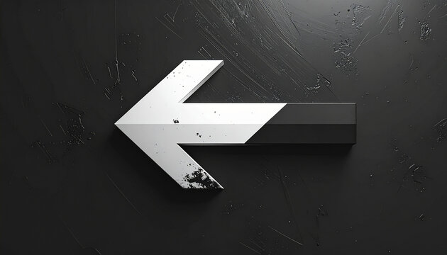 Large metallic left arrow sign on dark surface