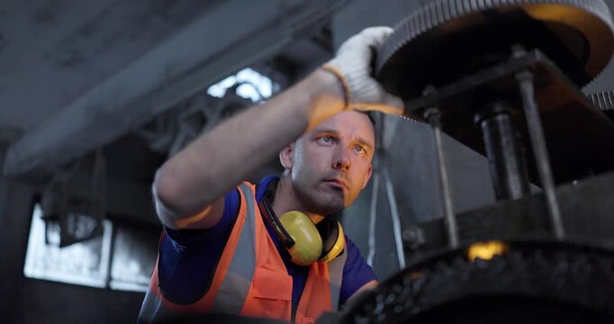  Technician Adjusting Heavy Industrial Machine in Traditional Metal Workshop