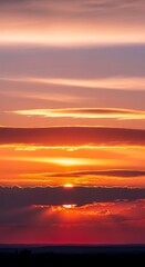 Obraz premium Vibrant Sunset Sky with Fiery Orange and Purple Hues.