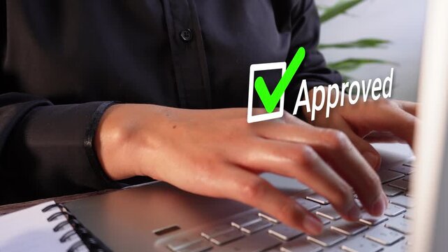 Close-up of a businesswoman's hands working on her computer with an animated checkmark and the word "Approved"