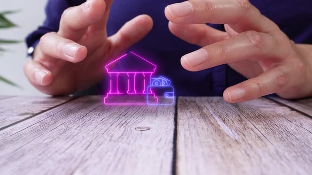 Bank account management. Close-up of a pair of hands on a table, protecting a virtual bank icon with a wallet.