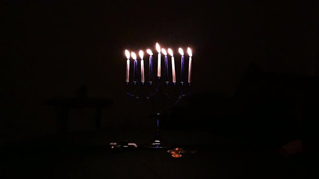 VIDEO horizontal. Lit menorah candles celebrating hanukkah holiday tradition. Black background