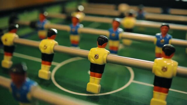 Table Soccer: Classic Foosball Table Soccer Football Game with Red and Blue Miniature Players in 4K Ultra HD footage.
