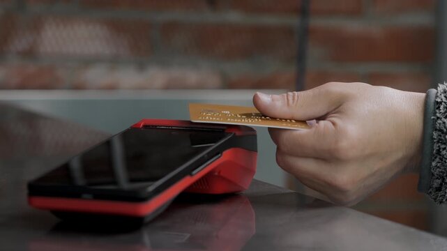 Close up of customer making contactless card payment at POS terminal in retail environment with cashless transaction technology.