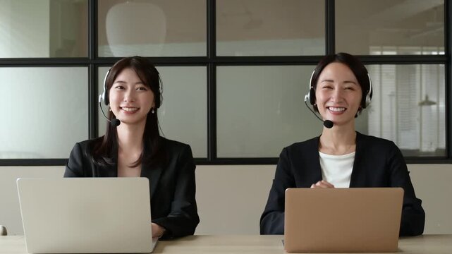 カメラ目線で微笑むコールセンターの日本人女性