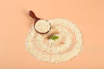 White sesame seeds in wooden spoon with mint leaf on beige background - healthy cooking ingredients © CaoVan
