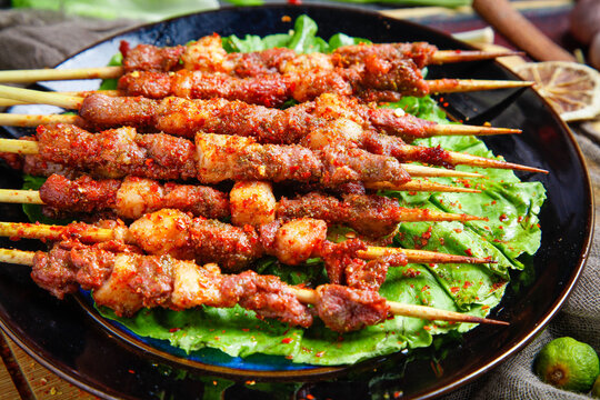 Zibo Style Grilled Lamb Kebabs on Lettuce - Traditional Chinese Street Food Barbecue from Night Market Stall