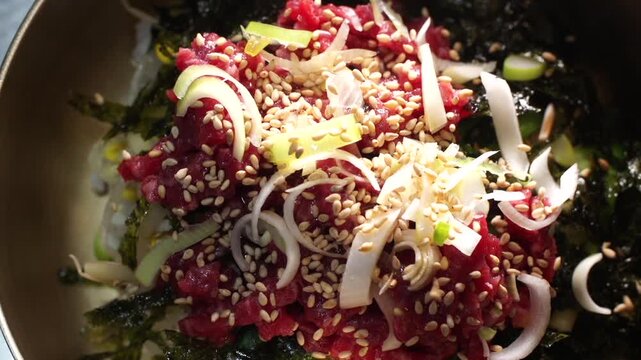 대한민국 한국 전통 음식 한우 생고기 비빔밥 육회 비빔밥 고명 참깨 뿌리기 대파 파 김가루 조리 과정 완성 단계 놋그릇 신선한 소고기 식재료 미식 맛집 외식 식문화 로컬 푸드 건강식 영양식 고단백 점심 저녁 식사 한식 요리 별미 정갈한 상차림 전통의 맛 고소한 풍미 클로즈업 근접 촬영 디테일