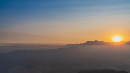 Obraz premium Sunrise. The rising sun is shining over the mountain range. The blue sky is highlighted with pink. There is fog and haze in the valley. Nepal. Sarangkot. The Himalayas. 