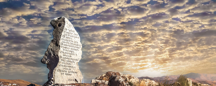 Ancient prehistoric Zorats Karer megalithic stone monument also known as Carahunge archaeological site in Armenia under beautiful dramatic sunset sky with clouds for history travel 