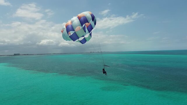 Couple parasailing in the Caribbean Sea in a beautiful paradisiacal location high above Cancun, Quintana Roo, Mexico