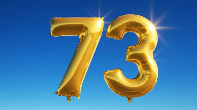 Celebrating Seventy Three Years of Life with Golden Number Balloons Against a Clear Blue Sky
