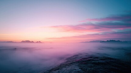 Fototapeta premium Serene Sunrise Over Misty Mountains with Soft Pink and Blue Sky Hues